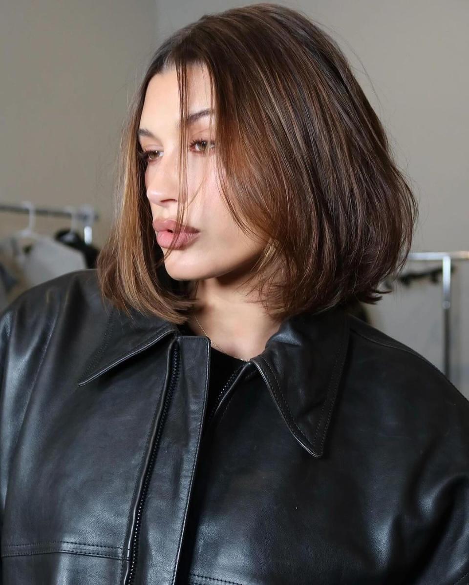 A model, Hailey Bieber, from the chest up with short, dark hair.