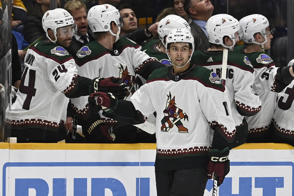 Arizona Coyotes right wing Dylan Guenther (11) is congratulated after scoring against the Nashville Predators during the second period of an NHL hockey game Saturday, Feb. 10, 2024, in Nashville, Tenn. (AP Photo/Mark Zaleski)