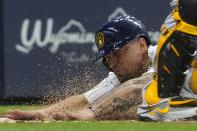 Milwaukee Brewers' Jace Peterson slides safely past Pittsburgh Pirates catcher Michael Perez during the second inning of a baseball game Friday, June 11, 2021, in Milwaukee. Peterson scored from third on a bunt by Brandon Woodruff. (AP Photo/Morry Gash)