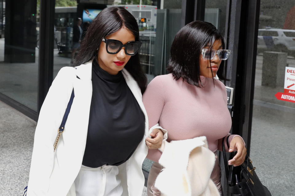 CORRECTS THE DESCRIPTION OF THE TWO WOMEN AS HAVING LIVED WITH R. KELLY RATHER THAN GIRLFRIENDS - Joycelyn Savage, left, and Azriel Clary, women who lived with R&B singer R. Kelly, depart the Dirksen Federal Courthouse after Kelly's hearing, Tuesday, July 16, 2019, in Chicago. U.S. District Judge Harry Leinenweber ordered R. Kelly held in a Chicago jail without bond on sex-related charges, saying that R&B singer had failed to convince the court that he would not be a danger if set free. (AP Photo/Charles Rex Arbogast)