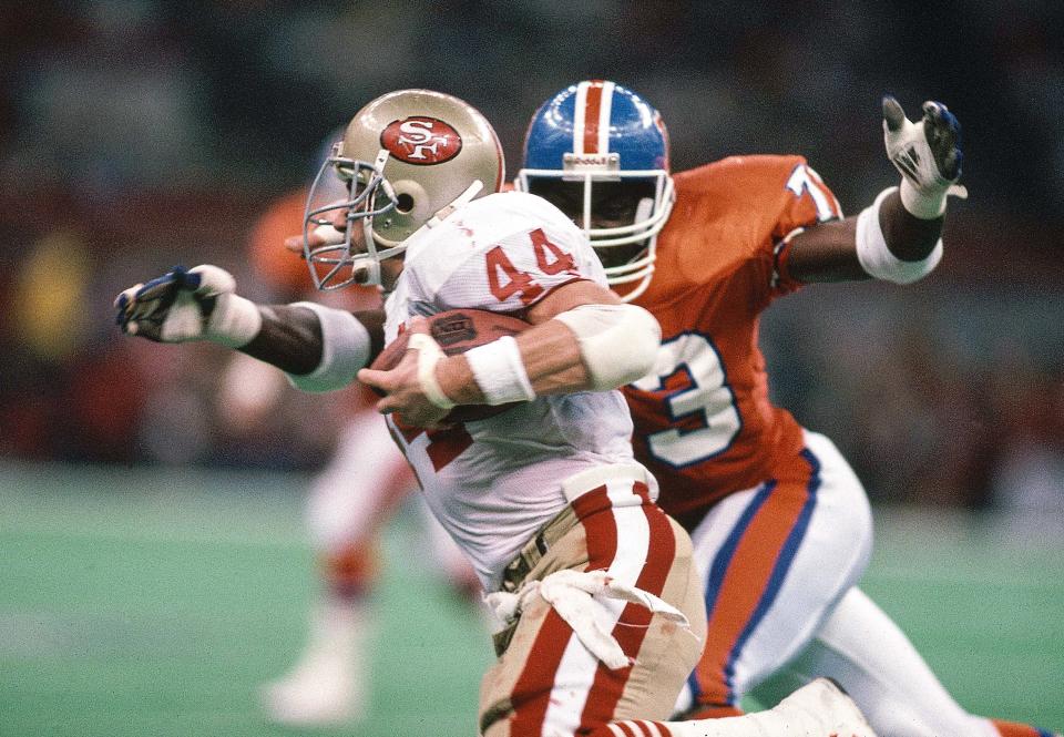 Jan 28, 1990; New Orleans, LA, USA; FILE PHOTO; San Francisco 49ers running back Tom Rathman (44) carries the ball under pressure from Denver Broncos linebacker Simon Fletcher (73) during Super Bowl XXIV at the Superdome. The 49ers defeated the Broncos 55-10. Mandatory Credit: Manny Rubio-USA TODAY Sports