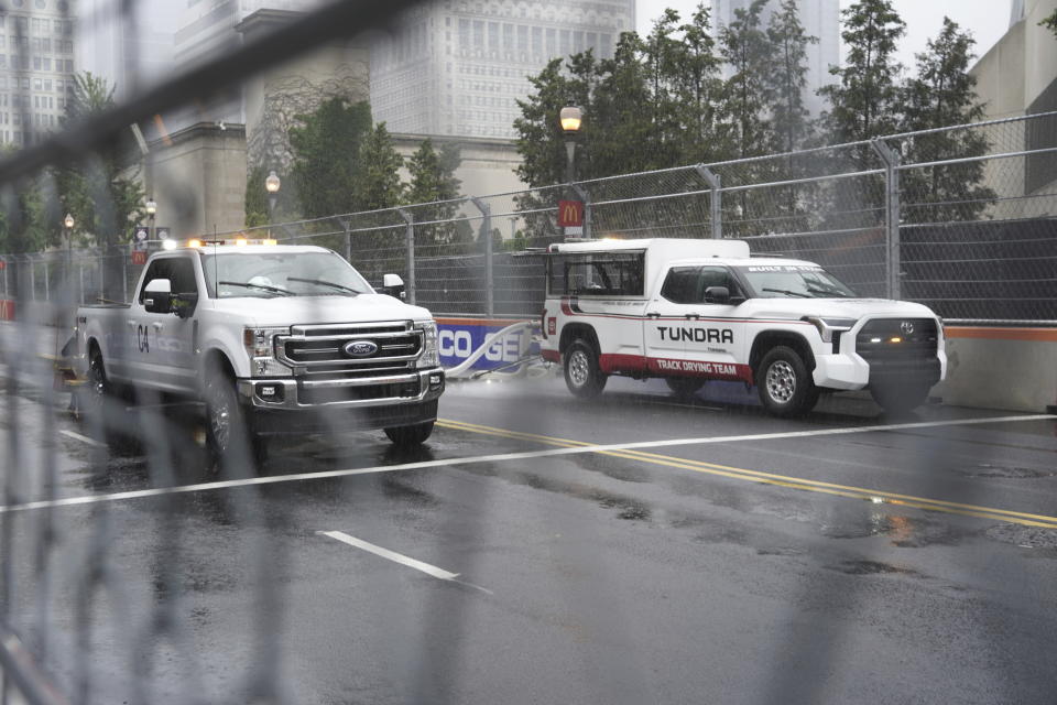 Crews try to dry the track in the rain before a NASCAR Cup Series auto race at the Grant Park 220 Sunday, July 2, 2023, in Chicago. (AP Photo/Morry Gash)