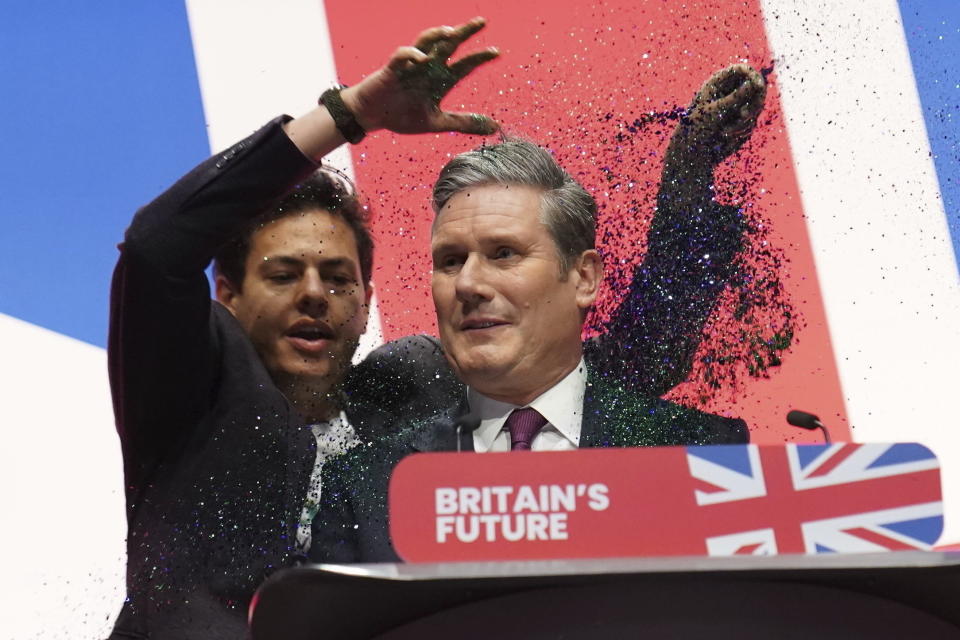 A protester throws glitter and disrupts Labour leader Sir Keir Starmer making his keynote speech during the Labour Party conference in Liverpool, England, Tuesday, Oct. 10, 2023. (Stefan Rousseau/PA via AP)