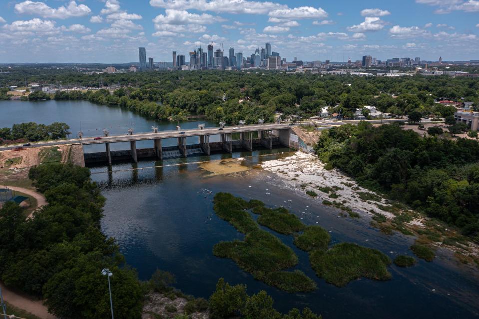 Water from the Colorado River flows past Longhorn Dam at the east end of Lady Bird Lake on Saturday. A pedestrian bridge will be built in this area to keep runners, walkers and bicyclists safe from the traffic on Pleasant Valley Road.