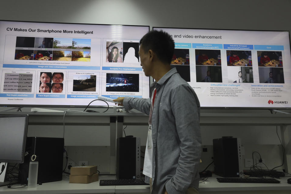 In this Aug. 19, 2019, photo, a Huawei employee introduces the work done at a lab specializing in the use of Artificial Intelligence at the Huawei Campus in Shenzhen in Southern China's Guangdong province. Facing a ban on access to U.S. technology, Chinese telecom equipment maker Huawei is showing it increasingly can do without American components and compete with Western industry leaders in pioneering research. (AP Photo/Ng Han Guan)