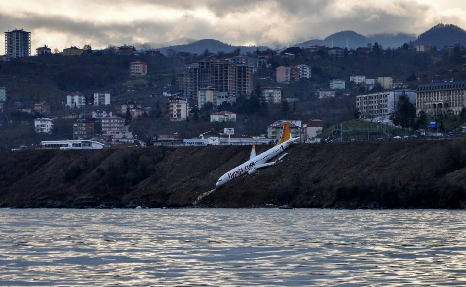 <p>A Pegasus Airlines Boeing 737 passenger plane is seen struck in mud on an embankment, a day after skidding off the airstrip, after landing at Trabzon’s airport on the Black Sea coast on Jan. 14, 2018. (Photo: AFP/Getty Images) </p>