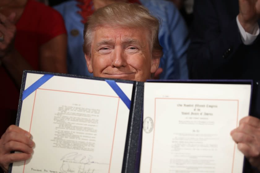 President Trump holds the Accountability and Whistleblower Protection Act of 2017 after signing it during a ceremony in the East Room of the White House June 23, 2017 in Washington, DC.