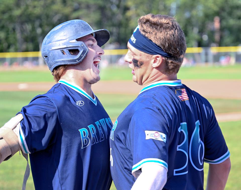 Carson DeMartini (left) chest bumps with his Brewster teammate Kurtis Byrne after hitting his second homerun putting them up 2-1 against Y-D.