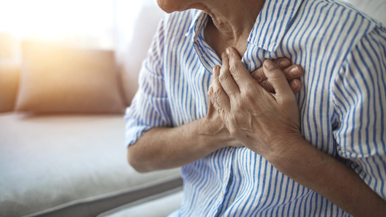 An image of a woman with her hands placed over her heart.