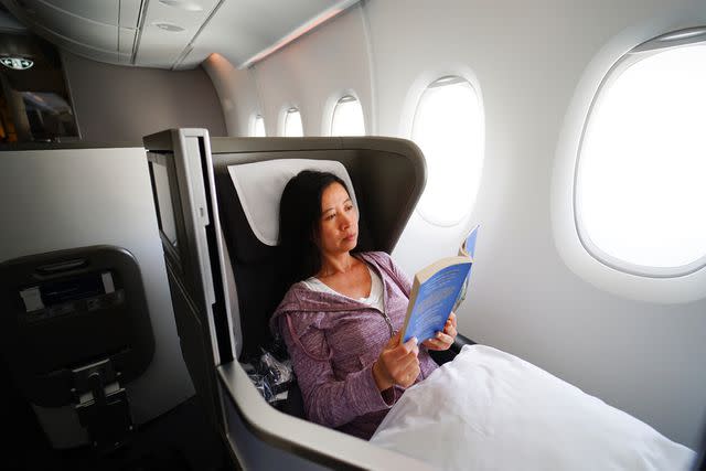 <p>Pete Ark/Getty Images</p> Consider swapping your in-flight movie for a book.
