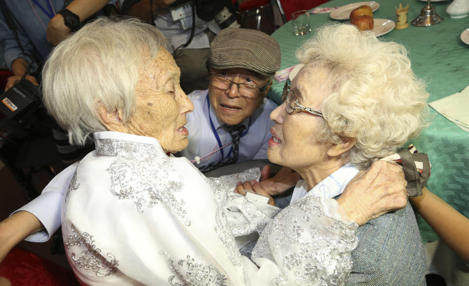 THIS ADDS NAME OF MAN AT CENTER - South Korean Cho Hye-do, 86, right, meets her North Korean sister Cho Sun Do, 89, left, accompanied by South Korean brother Cho Do-ja, 75, during the Separated Family Reunion Meeting at the Diamond Mountain resort in North Korea, Monday, Aug. 20, 2018. Dozens of elderly South Koreans crossed the heavily fortified border into North Korea on Monday for heart-wrenching meetings with relatives most haven't seen since they were separated by the turmoil of the Korean War. (Korea Pool Photo via AP)