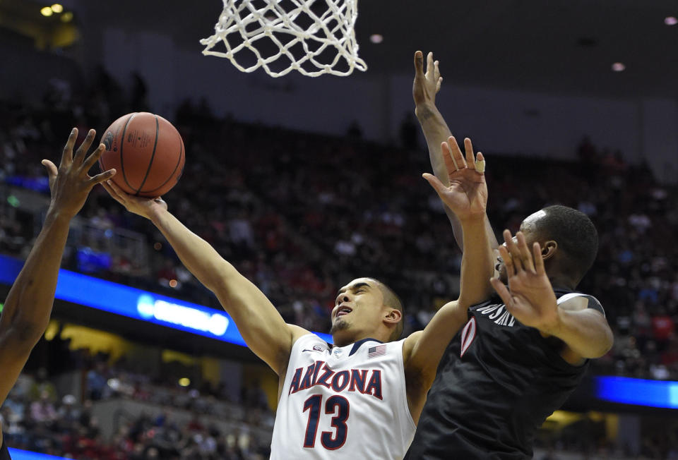 Arizona guard Nick Johnson (13) drives past San Diego State forward Skylar Spencer (0) during the first half in a regional semifinal NCAA college basketball tournament game, Thursday, March 27, 2014, in Anaheim, Calif. (AP Photo/Mark J. Terrill)