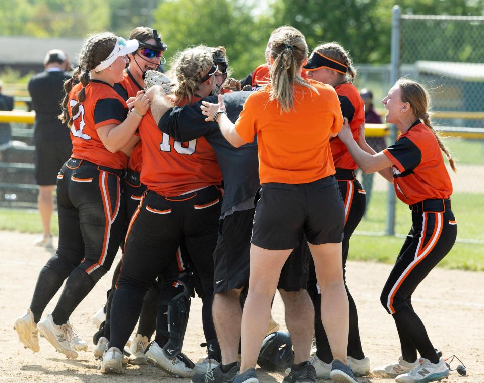 Players and coaches swarm Marlington pitcher Sofia Nase after she caught the last out to beat Aurora to win the Division II district final 1-0, Thursday, May 18, 2023, in Jefferson.