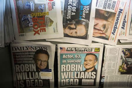 Newspapers announcing the death of comedian Robin Williams are stacked on a newsstand in New York August 12, 2014. REUTERS/Lucas Jackson