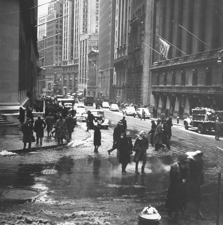 Old photo of New Yorkers walking through slush-covered streets.