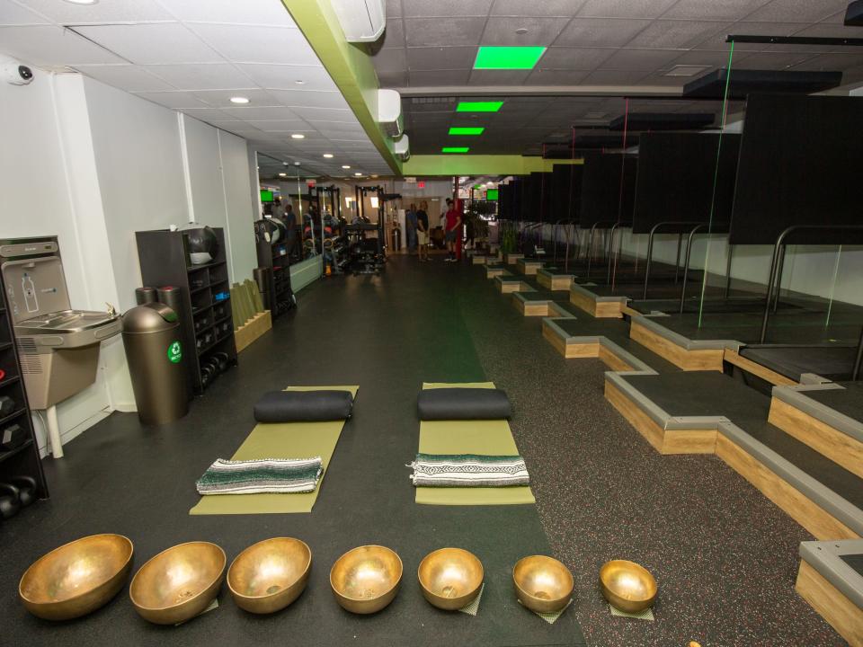 Inside Roam149's gym with yoga mats, treadmills, weights.