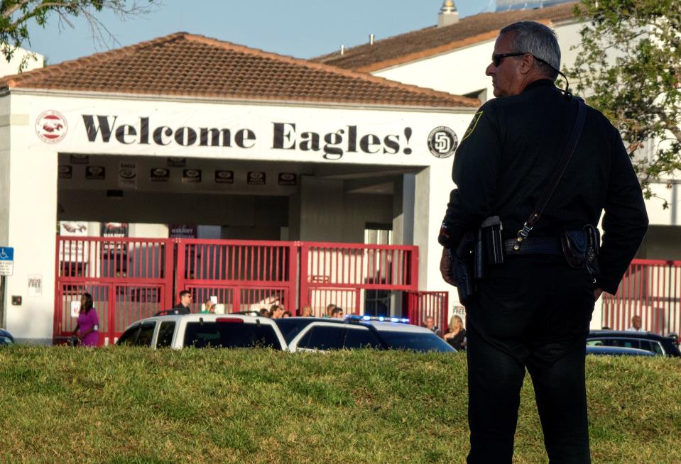 <p>Un policía hace guardia mientras padres y estudiantes llegan a la escuela Marjory Stoneman Douglas en Parkland, estado de Florida (Estados Unidos), hoy 28 de febrero de 2018. Dos semanas después de que un exalumno matara a 17 personas, las aulas de la escuela vuelven a llenarse de estudiantes, muchos de ellos convertidos en activistas contra las armas. EFE/ Cristobal Herrera </p>