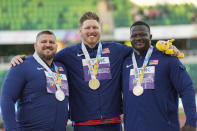 Gold medalist Ryan Crouser, of the United States, center, stands on the podium with silver medalist Joe Kovacs, of the United States, left, and bronze medalist Josh Awotunde, of the United States, during a medal ceremony for the men's shot put final at the World Athletics Championships on Sunday, July 17, 2022, in Eugene, Ore. (AP Photo/David J. Phillip)