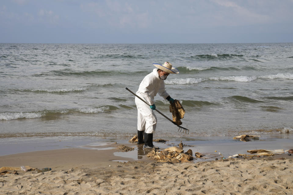 Workers carry out a cleanup operation on Mae Ramphueng Beach after a pipeline oil spill off the coast of Rayong province in eastern Thailand, Sunday, Jan. 30, 2022. The governor of a province in eastern Thailand on Saturday declared a state of emergency after an oil slick washed up on a sand beach, shutting down restaurants and shops in a setback for the pandemic-hit tourism industry. (AP Photo/Sakchai Lalit)