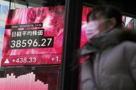 A person walks in front of an electronic stock board showing Japan's Nikkei 225 index at a securities firm Friday, Feb. 16, 2024, in Tokyo. Shares advanced in Asia on Friday, with Tokyo's benchmark Nikkei 225 index trading near a record high, 34 years after it peaked and then plunged with the collapse of Japan's financial bubble. (AP Photo/Eugene Hoshiko)