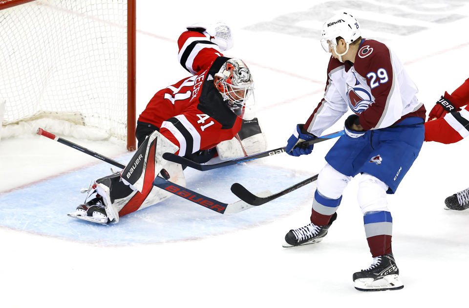 New Jersey Devils goaltender Vitek Vanecek (41) makes a save against Colorado Avalanche center Nathan MacKinnon (29) during the third period of an NHL hockey game, Tuesday, Feb. 6, 2024, in Newark, N.J. (AP Photo/Noah K. Murray)