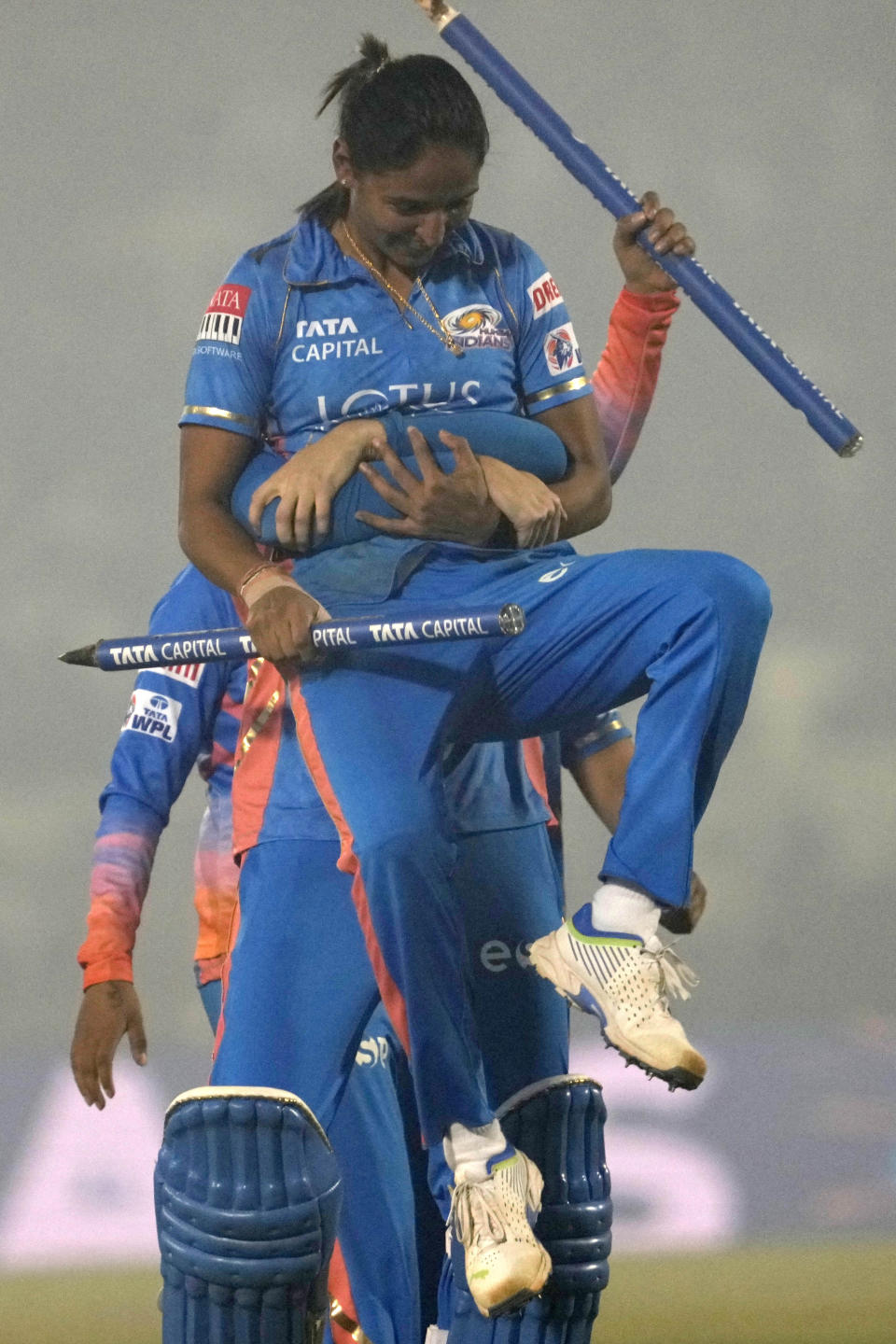 Mumbai Indians captain Harmanpreet Kaur is carried by teammate as they celebrate their win in the Women's Premier League Twenty20 cricket final match against Delhi Captials in Mumbai, India, Sunday, March 26, 2023. (AP Photo/Rajanish Kakade)