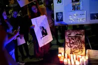 <p>Dr. Soraya Fallah (center), an Iranian Kurd, demonstrates with an image of Zhina Mahsa Amini at a candlelit vigil following her death, outside the Wilshire Federal Building in Los Angeles, California, U.S., September 22, 2022. REUTERS/Bing Guan</p> 