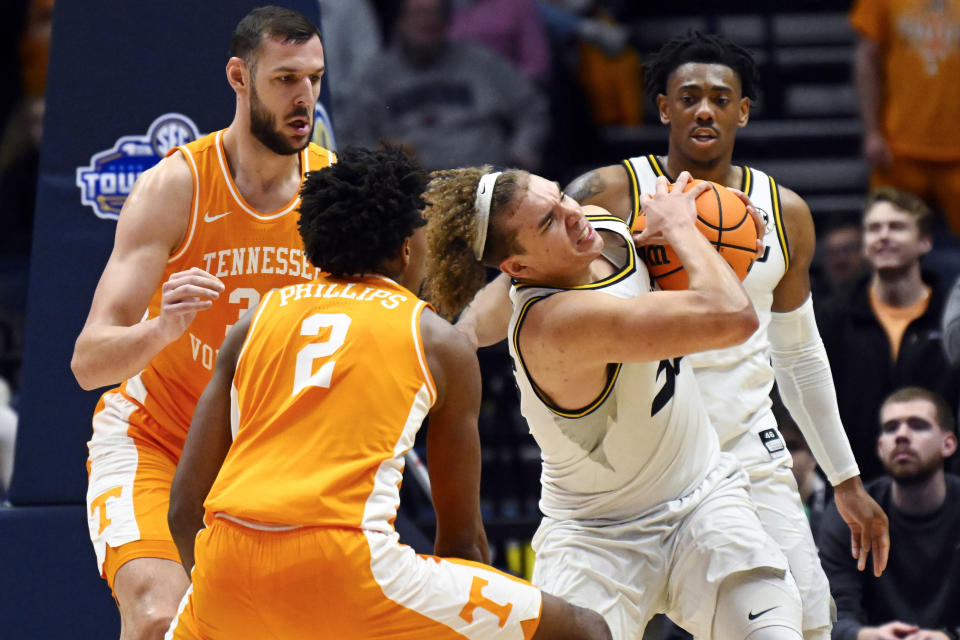 Missouri forward Noah Carter grabs a rebound from Tennessee forward Uros Plavsic, left, and forward Julian Phillips (2) during the second half of an NCAA college basketball game in the quarterfinals of the Southeastern Conference Tournament, Friday, March 10, 2023, in Nashville, Tenn. Missouri won 79-71. (AP Photo/John Amis)