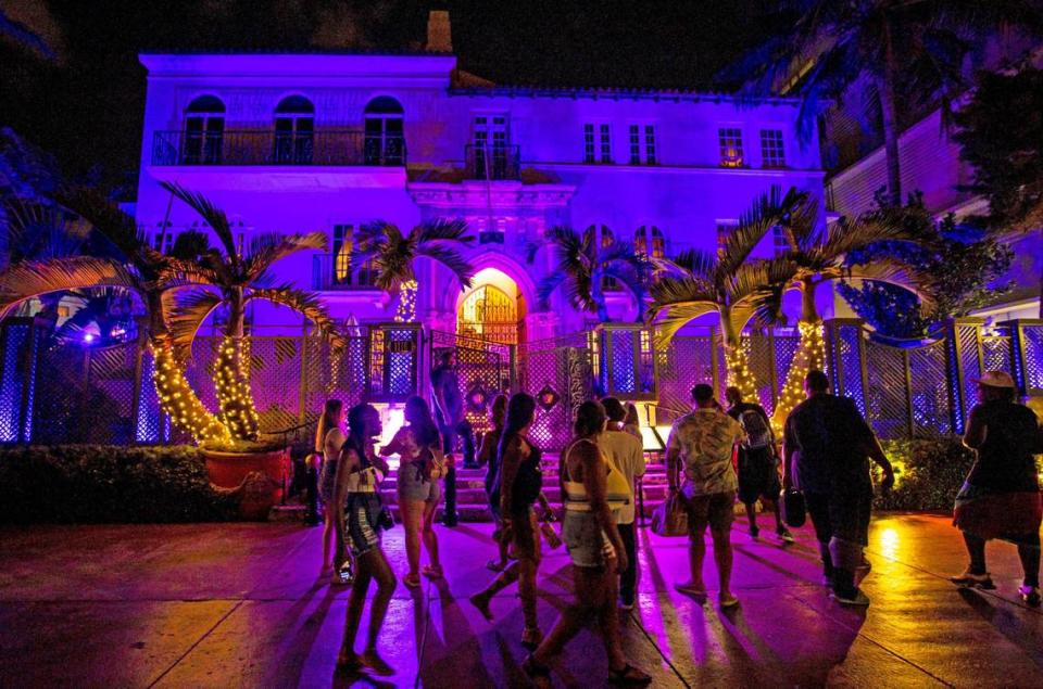 People walk past The Villa Casa Casuarina At The Former Versace Mansion off Ocean Drive during the first day of Memorial Day Weekend in Miami Beach, Florida, on Friday, May 27, 2022.