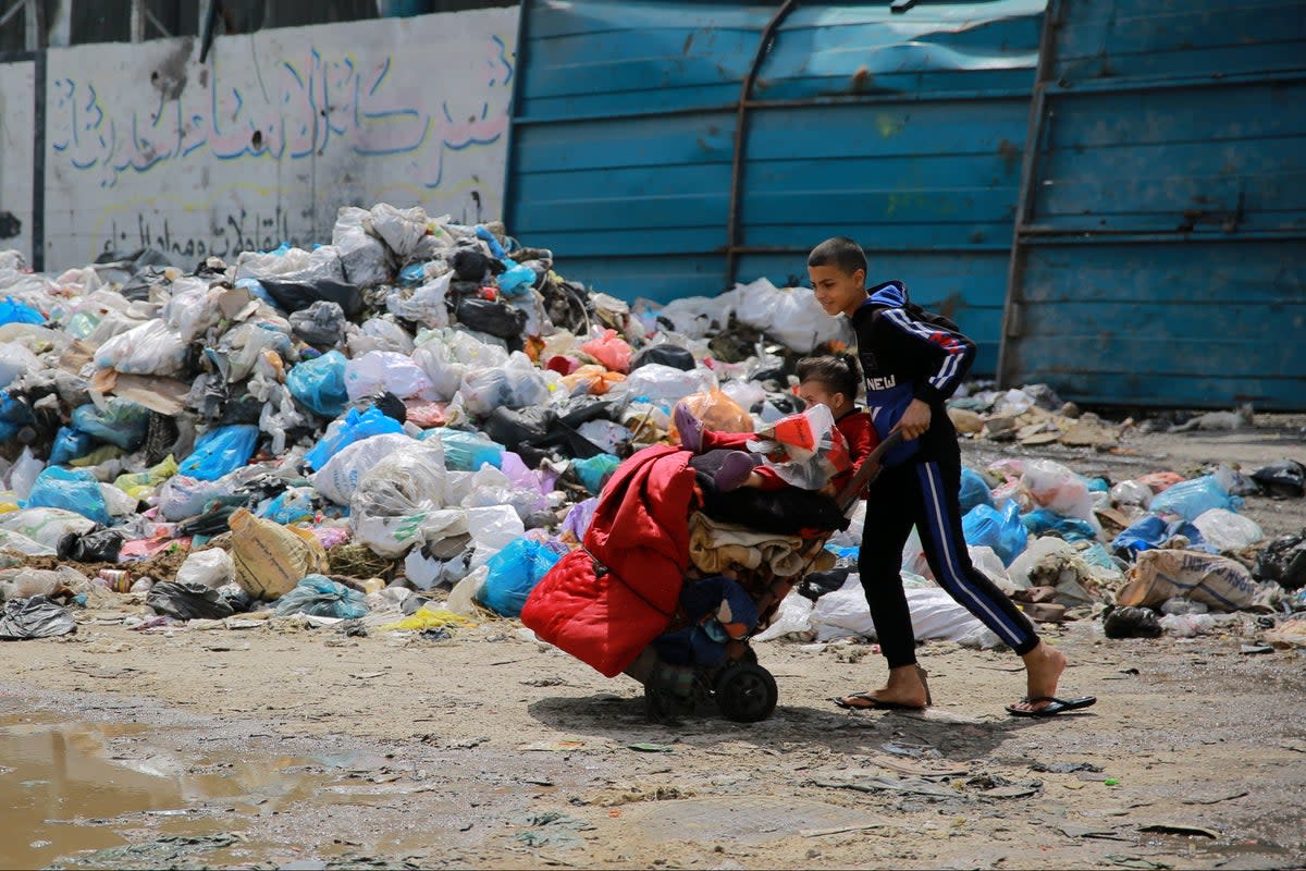 A child walks through Gaza City with belongings (AFP via Getty Images)