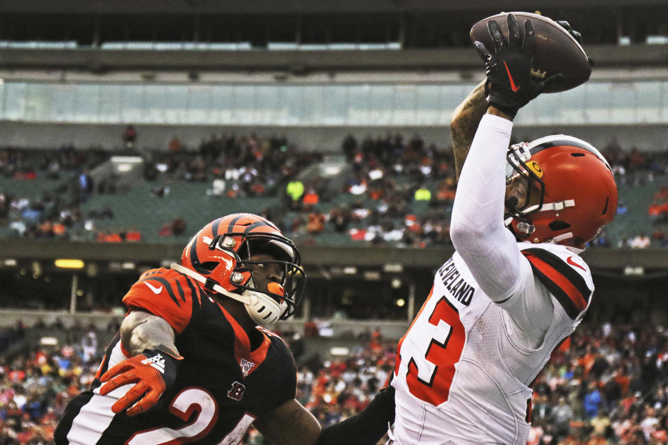 Cleveland Browns wide receiver Odell Beckham Jr., right, catches a 20-yard touchdown pass under pressure from Cincinnati Bengals cornerback Darius Phillips, left, during the second half of an NFL football game, Sunday, Dec. 29, 2019, in Cincinnati. (AP Photo/Gary Landers)