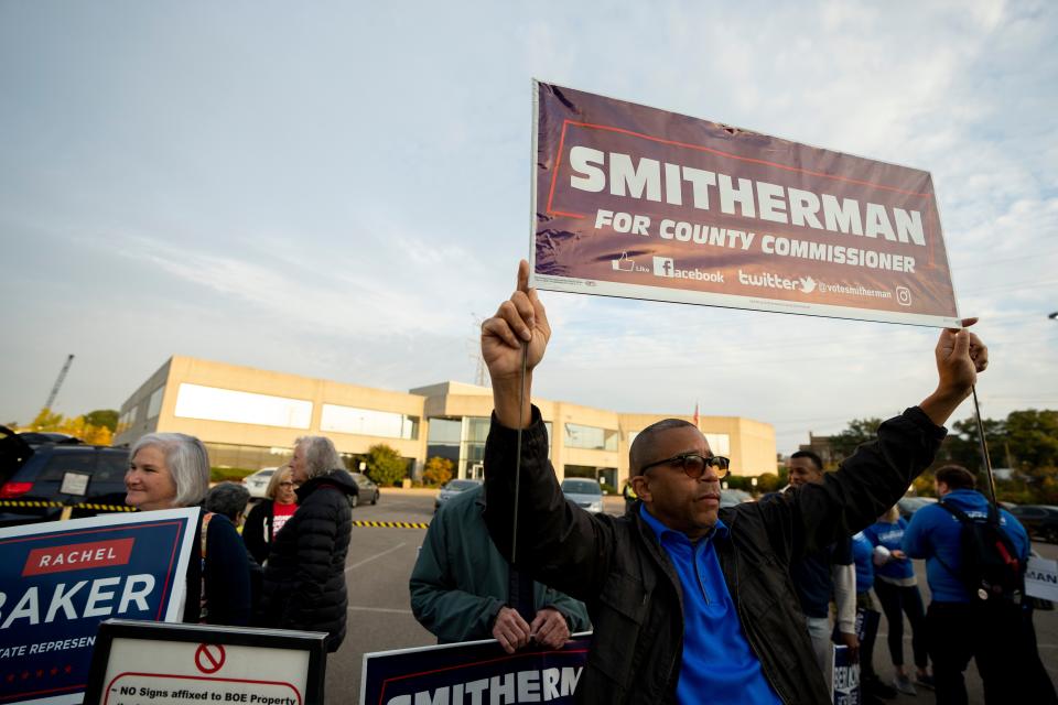 Christopher Smitherman, a candidate for Hamilton County Commissioner, holds a sign while campaigning in the 2022 midterm election outside the Hamilton County Board of Elections in Norwood on Wednesday, Oct. 12, 2022. 