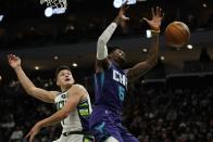 Milwaukee Bucks' Grayson Allen and Charlotte Hornets' Jalen McDaniels go after a loose ball during the first half of an NBA basketball game Wednesday, Dec. 1, 2021, in Milwaukee. (AP Photo/Morry Gash)