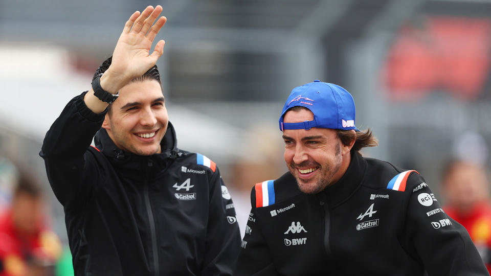 Alpine F1 drivers Esteban Ocon and Fernando Alonso are seen waving to the crowd at the Hungarian Grand Prix.