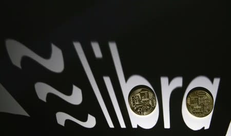 FILE PHOTO: Shadow of a 3D-printed Facebook Libra cryptocurrency logo is seen near cryptocurrency representation in this illustration taken