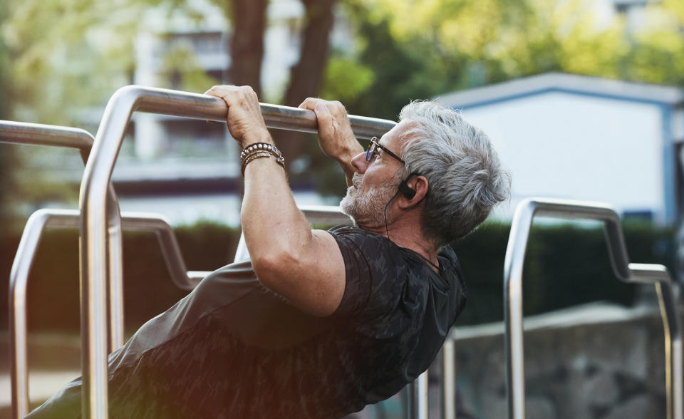 elderly handsome man exercising in an outdoor gym