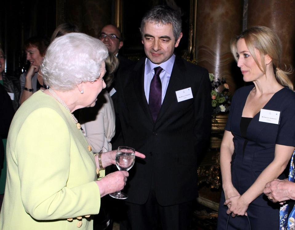 Queen Elizabeth II meets actors Rowan Atkinson and Gillian Anderson at a reception to celebrate the 200th anniversary of Charles Dickens’s birth on February 14, 2012, in London.