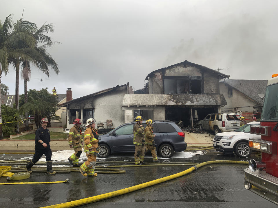 Firefighters respond to the scene of a plane crash at a home in Yorba Linda, Calif., Sunday, Feb. 3, 2019. A twin-engine Cessna 414A crashed in Yorba Linda shortly after taking off from the nearby Fullerton Municipal Airport. The Orange County Fire Authority said the crash in a Yorba Linda neighborhood ignited a fire that burned the house Sunday afternoon. (AP Photo/Alex Gallardo)