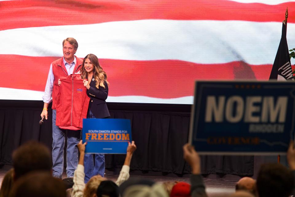 Glenn Youngkin, Governor of Virginia, gives one of his signature red vests to Governor Kristi Noem at a rally supporting her on Wednesday, November 2, 2022, at the South Dakota Military Heritage Alliance in Sioux Falls.