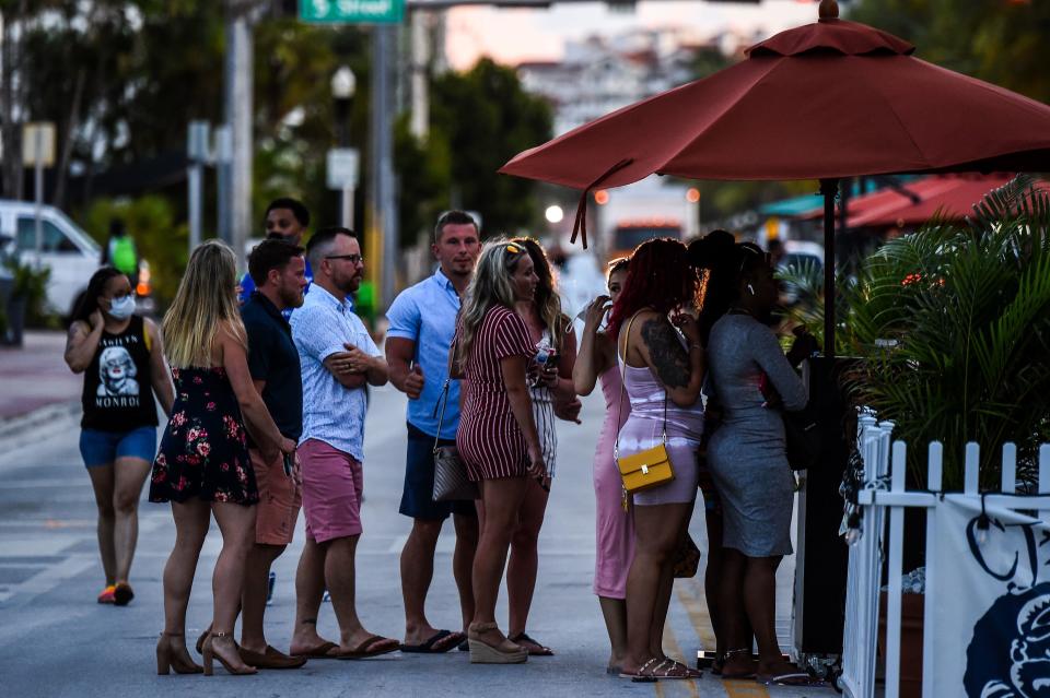 People stand in queue to enter a restaurant on Ocean Drive in Miami Beach, Florida on June 26, 2020. / Credit: CHANDAN KHANNA/AFP via Getty Images