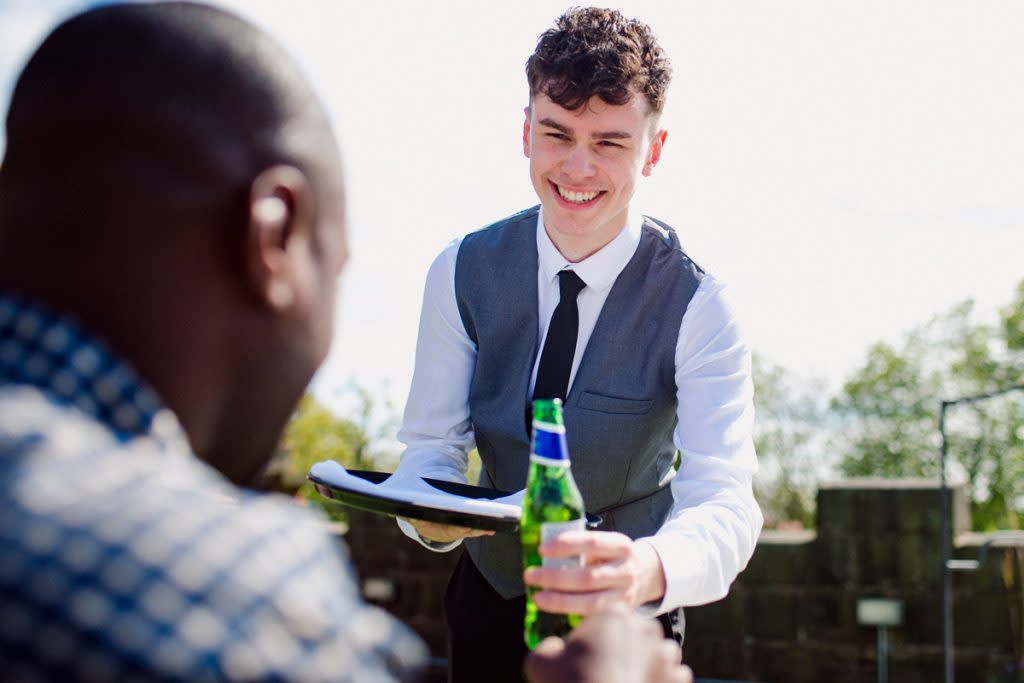 A male serves a beer to a customer.