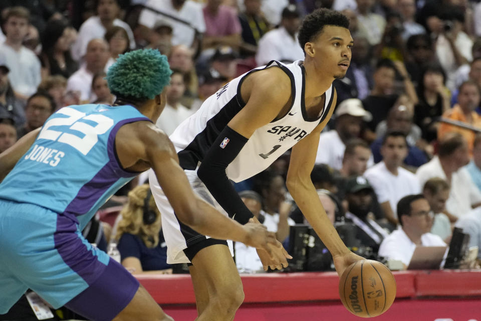 San Antonio Spurs' Victor Wembanyama drives against Charlotte Hornets' Kai Jones during the first half of an NBA summer league basketball game Friday, July 7, 2023, in Las Vegas. (AP Photo/John Locher)