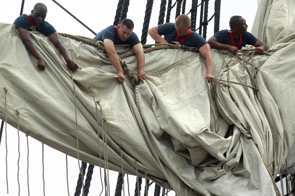 U.S. Navy personnel gather sails in the rigging of the USS Constitution as the vessel arrives at her berth in Charlestown Navy Yard, in Boston, Sunday, Aug. 19, 2012. The U.S. Navy's oldest commissioned war ship sailed under her own power Sunday for the first time since 1997. The sail was held to commemorate the 200th anniversary of the ship's victory over HMS Guerriere in the War of 1812. (AP Photo/Steven Senne)