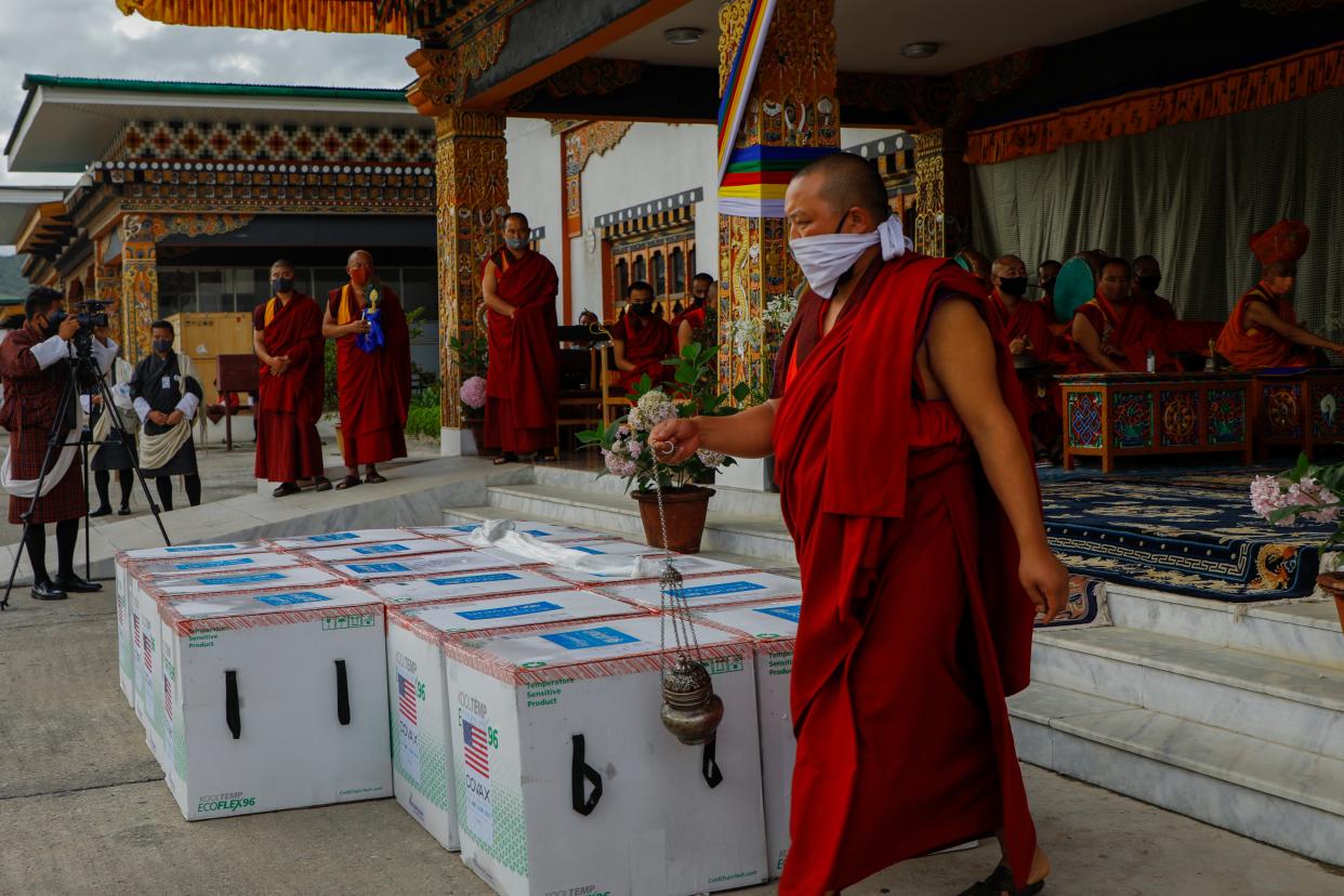 This photograph provided by Unicef shows monks from Paro’s monastic body performing a ritual as 500,000 doses of Moderna vaccine gifted from the United States arrive at Paro International  (AP)