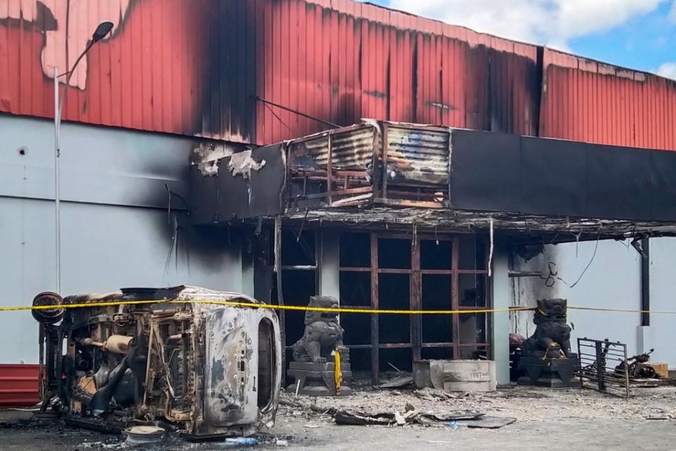 The burnt out Double O nightclub is seen where at least 18 people were killed in clashes between two groups, in Sorong in Indonesia’s West Papua province on 25 January 2022 (AFP via Getty Images)