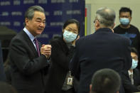 Chinese Foreign Minister Wang Yi, left, is greeted by attendees as he arrives the Lanting Forum on bringing China-U.S. relations back to the right track, at the Ministry of Foreign Affairs office in Beijing on Monday, Feb. 22, 2021. Wang called on the U.S. Monday to lift restrictions on trade and people-to-people contacts while ceasing what Beijing considers unwarranted interference in the areas of Taiwan, Hong Kong, Xinjiang and Tibet. (AP Photo/Andy Wong)