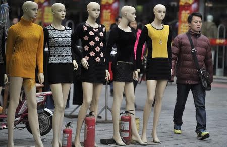 A man walks past mannequins at a wholesale market in Hefei, Anhui province, February 9, 2014. REUTERS/Stringer