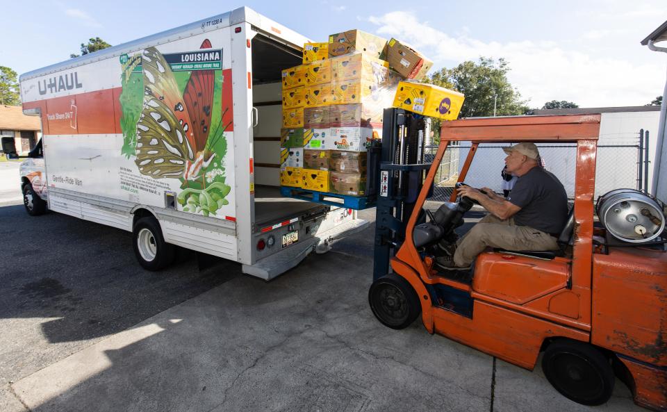 The executive director of First Step Food Bank loads a pallet of food for a client on Nov. 14 at the First Step Food Bank in Ocala