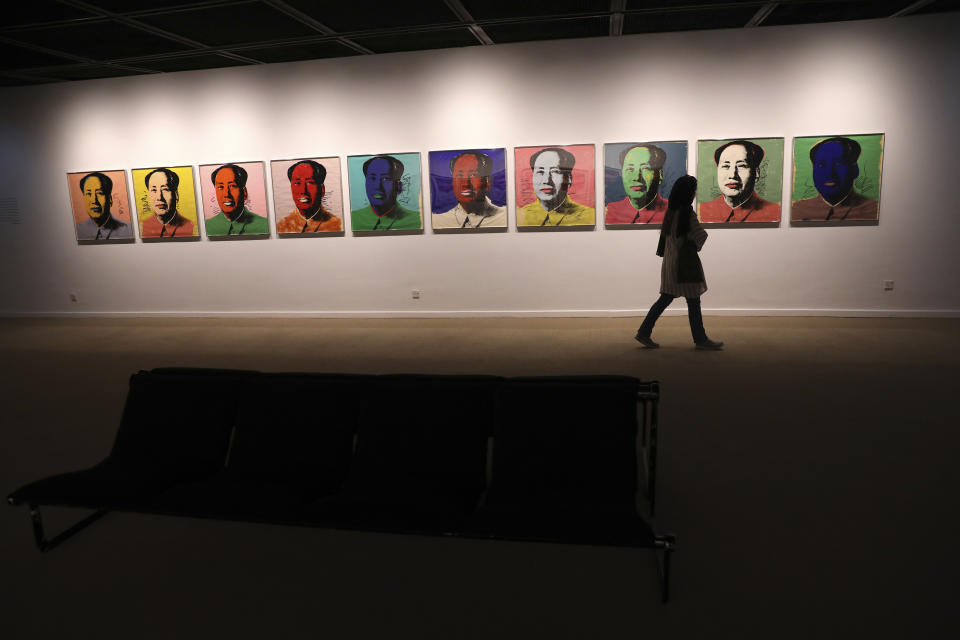 A visitor walk past China's late leader, Mao Zedong painting series by American artist Andy Warhol at Tehran Museum of Contemporary Art in Tehran, Iran on Oct. 19, 2021. Iranians are flocking to Tehran's contemporary art museum to marvel at American pop artist Andy Warhol’s iconic work. (AP Photo/Vahid Salemi)