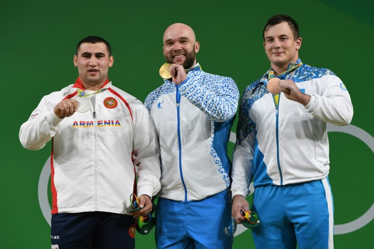 Uzbekistan's gold medallist Ruslan Nurudinov (C), Armenia's silver medallist Simon Martirosyan (L) and Kazakhstan's bronze medallist Alexandr Zaichikov on the podium after the men's 105kg weightlifting competition